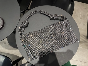 Detail of silver rhinestone evening bag with knotted handle showing sparkling crystals
