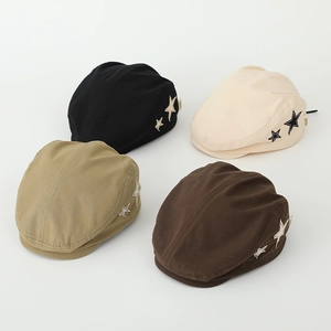 Detail view of four colors of kids beret hats featuring star patches on the side