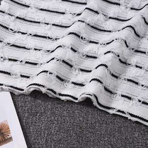 Detail of white striped fabric featuring 3D mesh flower appliques and woven texture