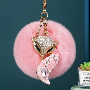 Détail du porte-clés renard en fourrure rose avec strass brillants et métal doré