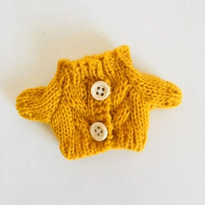 Gelbe handgestrickte Mini-Strickjacke für Puppen mit Zopfmuster und dekorativen Holzknöpfen