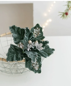 Close-up of dark green velvet Christmas flower with silver sequins in a white basket