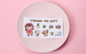 Close-up of cute cartoon stickers with girls and bears on a pink decorative plate