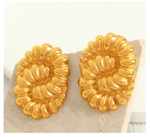 Macro shot of gold vintage twisted earrings with a unique spiral sunburst texture design