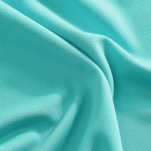 Macro shot of cyan polo shirt fabric with breathable honeycomb pique knit texture