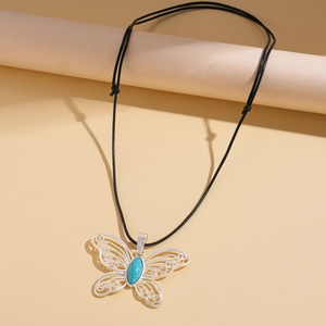 Detailed close-up of hollow butterfly pendant with blue stone on black wax cord
