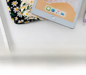 Detail of embroidered daisy flowers on quilted padded laptop sleeve fabric