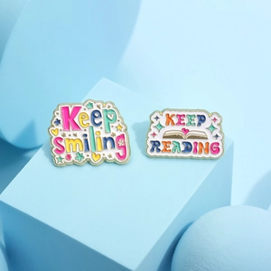 Colorful Keep Smiling and Keep Reading enamel pins on minimalist blue background