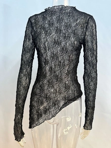 Vue détaillée du haut en dentelle noire transparente à manches longues et ourlet irrégulier