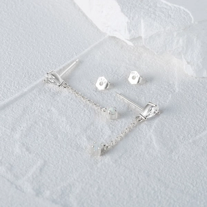 Macro detail of S925 sterling silver teardrop earrings with opal stones on stone background