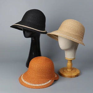Detail of raffia sun hat weave texture and dome shape with contrast ribbon band