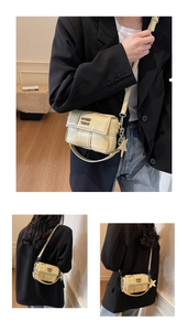 Détail du sac bandoulière tissé beige avec chaîne en métal et boucle décorative