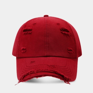 Distressed dark red cotton baseball cap with vintage frayed edges and streetwear style