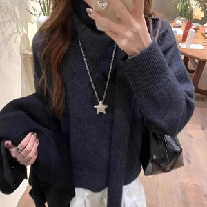 Collier avec pendentif étoile en zircon pour femme porté sur un col roulé gris chiné