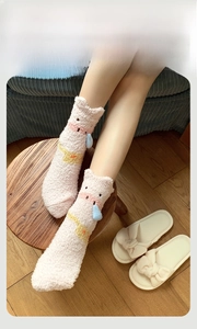 Gros plan de chaussettes épaisses en polaire corail rose avec détails de dessins animés