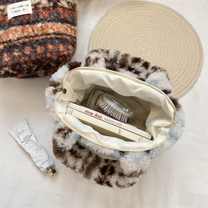 Spacious interior of plush leopard print handbag showing storage capacity with daily items