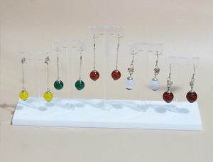 Close-up of five pairs of colorful beaded drop earrings on acrylic jewelry display stand