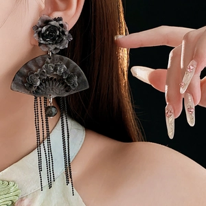 Detail of vintage flower fan earrings with long tassels on model showing retro style