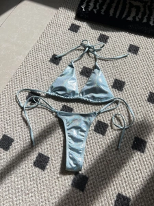 Close-up of light blue laser bikini with shimmering metallic glitter and ring detail