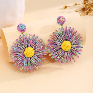 Macro detail of handmade oversized raffia flower earrings with colorful woven petals