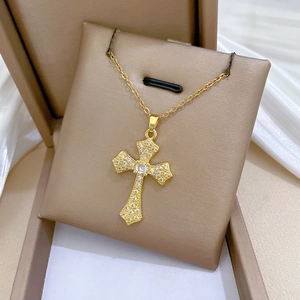 Luxurious gold titanium cross necklace with sparkling crystals on a premium display box