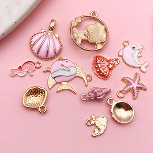 Pink and gold ocean themed alloy charms set featuring seashells and sea life on pink background