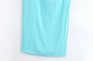 Gros plan détaillé du tissu en coton et lin bleu clair montrant la texture naturelle et l'ourlet