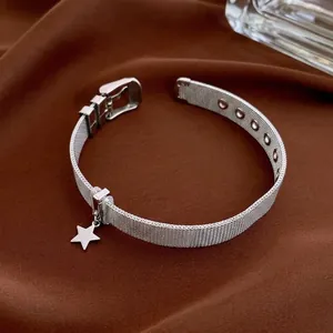 Modern silver mesh star bracelet with adjustable buckle on a neutral fabric background