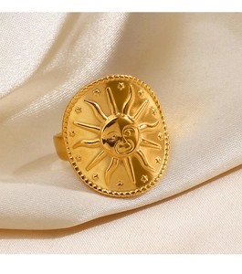 Detailed close-up of a gold celestial sun relief ring on soft beige silk fabric