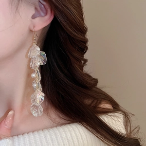 Detailed view of long tassel earrings with translucent iridescent petals and small pearls