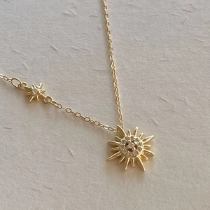 Close-up of a 925 sterling silver gold star necklace with sparkling zircon pendants