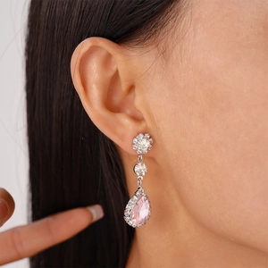 Close-up of elegant silver flower earrings with pink teardrop crystal and pavé rhinestones