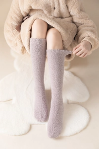 Detail view of soft light pink coral fleece over-knee socks for winter warmth and home comfort
