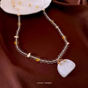 Elegant beaded necklace with white agate pendant on silk background, luxurious jewelry