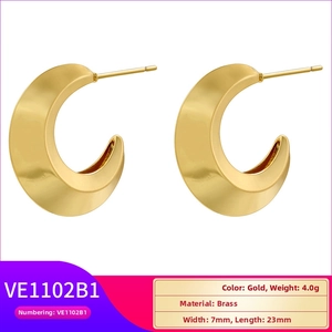 Macro detail of wide gold C-shaped brass earrings showing 7mm width and 23mm length size