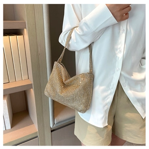 Close-up of sparkling gold rhinestone handbag with detailed craftsmanship and zipper