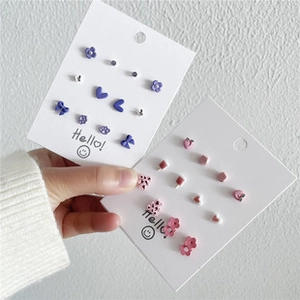 Close-up of pastel purple and pink resin earring set with flower and butterfly designs