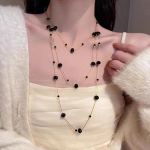 Elegant multi-layer gold necklace with black faceted beads for a sophisticated layered look
