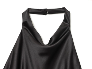Détail d'une robe dos nu en satin noir montrant la texture soyeuse et la fermeture à boutons