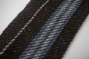 Detail shot of winter scarf with mixed fringe, stripe pattern and wool texture fabric