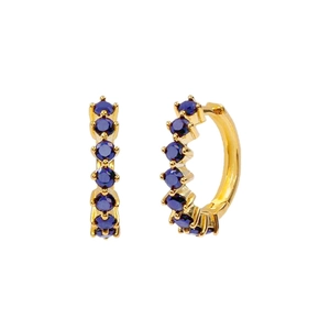 Detail of gold huggie hoop earrings featuring six inlaid round dark blue cubic zirconia