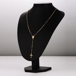 Golden stainless steel rosary necklace with Madonna medal and cross pendant on mannequin