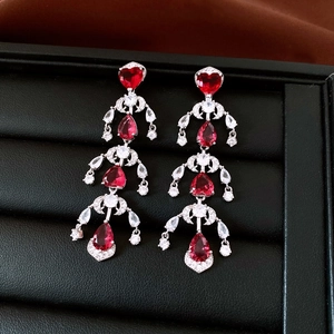 Detailed close-up of red heart-shaped gemstone tassel earrings with silver accents