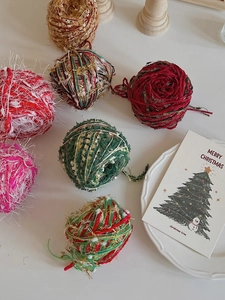 Close-up of colorful DIY Christmas textured yarn balls with glitter for holiday crafting