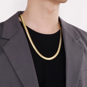 Men in grey suit wearing a trendy gold titanium flat snake bone chain necklace