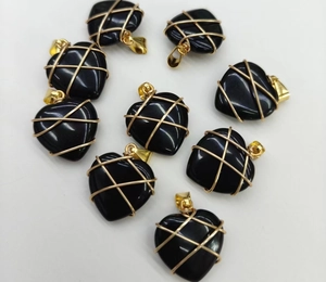 Detail view of heart-shaped black agate pendants with intricate gold wire wrapping details
