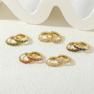 Detail view of five pairs of small gold hoop earrings set with colorful zircon stones