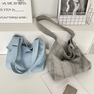 Detail view of large canvas tote bags in light blue and grey with wide adjustable straps