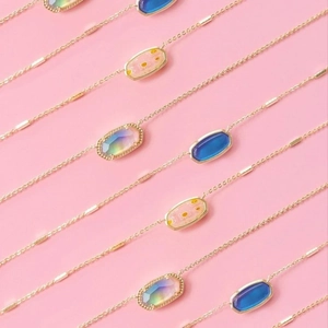 Detailed macro view of gold birthstone pendants with colorful resin floral patterns