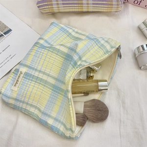 Plaid canvas makeup bag interior showing large capacity for skincare and brushes
